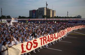 In this May 1, 2014 file photo, doctors parade in the May Day march in Havana, Cuba. The Cuban government announced on the front page of state media Tuesday, Dec. 1, 2015, that doctors in specialties that have been drained by large-scale emigration in recent years will now be required to get permission from Health Ministry officials in order to leave the country. (AP Photo/Ramon Espinosa, File)