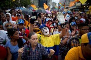 Supporters of the Mesa de la Unidad (MUD) political party cheer during a closing campaign rally in Caracas, Venezuela, Wednesday, Dec. 2, 2015. The Dec. 6 ballot for Venezuelan congressional elections has more than two dozen parties competing in a contest that represents the stiffest challenge in 16 years for Venezuela's ruling socialist party. (AP Photo/Ariana Cubillos)
