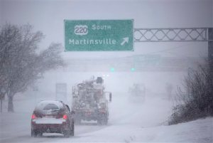 Cars make their way down Electric Road in southwest Roanoke County past Tanglewood Mall on Friday morning, Jan. 22, 2016, near Roanoke, Va. A blizzard menacing the Eastern United States started dumping snow in Virginia, Tennessee and other parts of the South on Friday as millions of people in the storm's path prepared for icy roads, possible power outages and other treacherous conditions. (Erica Yoon/The Roanoke Times via AP)