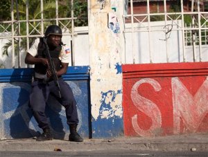 A National Police officer takes position as police work to disperse a crowd protesting against President Michel Martelly's government, in Port-au-Prince, Haiti, Saturday, Jan. 23, 2016. A presidential runoff that had already been delayed once and faced deep public skepticism was put on hold indefinitely Friday. The Saturday protesters are demanding that Martelly leave office Feb. 7, as is required under the Constitution, and an interim government take power. (AP Photo/Dieu Nalio Chery)
