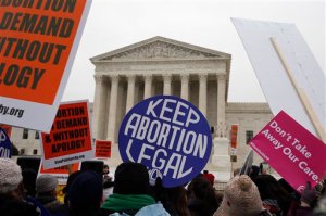 FILE - In this Jan. 22, 2016 file photo, pro-abortion rights signs are seen during the March for Life 2016, in front of the U.S. Supreme Court in Washington. The Supreme Court will not allow North Dakota to enforce a law banning abortions when a fetal heartbeat is detected as early as six weeks into a pregnancy. The justices on Monday, Jan. 25, 2016, turned away the states appeal of lower court rulings that struck down the 2013 fetal heartbeat law as unconstitutional. The law never took effect and abortion rights supporters said it was the strictest anti-abortion measure in the country.  (AP Photo/Alex Brandon, File)