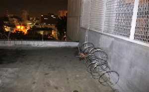 This Jan. 23, 2016 photo provided by the Orange County Sheriff's Office shows the exterior of Central Men's Jail in Santa Ana, Calif., showing where razor wire was removed from a parapet, center rear, and a rope-like line, seen at right, which authorities believe three inmates used to repel to the ground during their escape sometime Friday, Jan. 22. (Orange County Sheriff's Office via AP)