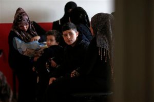 In this Wednesday, Jan. 6, 2016 photo, Syrian refugees sit in a Doctors Without Borders clinic at the Shatila refugee camp in Beirut, Lebanon. In a report published Tuesday, Jan. 12, 2016, the New York-based rights group Human Rights Watch said Lebanese residency laws are putting Syrian refugees in danger. The regulations, adopted a year ago, have forced refugees to either return to Syria, where they are at risk of persecution, torture or death, or to stay in Lebanon illegally, leaving them vulnerable to exploitation and abuse. (AP Photo/Hassan Ammar, File)