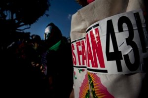 FILE - In this Dec. 26, 2015, file photo, Relatives of the 43 missing students from the Isidro Burgos rural teachers college march holding pictures of their missing loved ones during a protest in Mexico City. Mexican authorities said on Friday, Jan. 22, 2016, that they have arrested three more suspects in the disappearance of the 43 students in 2014 in southern Mexico. (AP Photo/Marco Ugarte, File)