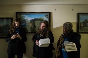Lynna Kaucheck, senior organizer at Food and Water Watch, Flint resident Melissa Mays, a founder of Water You Fighting For?, and Lila Cabbil of Detroit's People's Water Board, each stand along the wall outside of Flint Mayor Karen Weaver's office with petitions containing more than 21,000 signatures to demand a moratorium on water bills in the city on Thursday, Jan. 28, 2016, at City Hall in downtown Flint, Mich. Flint's water became contaminated when the city, under emergency state management, switched from the Detroit municipal system and began drawing from the Flint River in April 2014 to save money. (Jake May/The Flint Journal-MLive.com via AP) LOCAL TELEVISION OUT; LOCAL INTERNET OUT; MANDATORY CREDIT