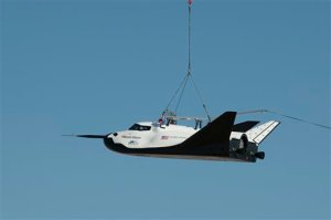 In this Aug. 22, 2013 photo provided by NASA, Sierra Nevada Corporation's Dream Chaser engineering test spacecraft is suspended from a cable from a large helicopter during a test at the NASA Dryden site in California. On Thursday, Jan. 14, 2016, Nasa announced the Sierra Nevada Corp. will join SpaceX and Orbital ATK in launching cargo to the International Space Station. These flights, yet to be finalized, will run through 2024. (Carla Thomas/NASA via AP)