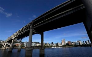 FILE - In this Aug. 4, 2015, file photo, downtown Portland, Ore., is visible under the Interstate-5 Marquam Bridge on the Willamette River. There are numerous bridges in Portland spanning the river, varying in age and ability to withstand a major earthquake. For the past few years emergency officials in the Pacific Northwest have been drafting detailed contingency plans for the day a mega-quake and tsunami hit the region. What planners envision is a massive response that would eclipse the response to any natural disaster so far in U.S. history.  (AP Photo/Don Ryan, File)