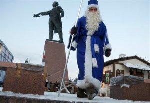 An actor dressed as Grandfather Frost, the Russian Santa Claus, walks next to a statue of Soviet Union founder Vladimir Lenin during celebration of Orthodox Christmas in St.Petersburg, Russia, Thursday, Jan. 7, 2016. Russian Orthodox believers celebrate Christmas by the Julian calendar on Jan. 7. (AP Photo/Dmitry Lovetsky)