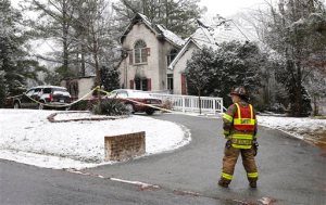 A firefighter stands on the scene where a house fire took place, Sunday, Jan. 17, 2016 in Chesterfield County, Va. Emergency response officials say five people were killed in the early morning fire in suburban Richmond. (Alexa Welch Edlund/Richmond Times-Dispatch via AP)