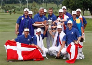 Members of Team Europe, top row left to right, Danny Willet of England, Andy Sullivan of England, Darren Clarke of Northern Ireland, Victor Dubuisson of France, Ian Poulter of England, Lee Westwood of England, Ross Fisher of England, Kristoffer Broberg of Sweden, Shane Lowry of Ireland, front row left to right, Soren Kjeldsen of Denmark, Matthew Fitzpatrick of England, Chris Wood of England and Bernd Wiesberger of Austria, pose for photos with their trophy after winning the Eurasia Cup golf tournament at the Glenmarie Golf and Country Club in Subang, Malaysia, Sunday, Jan. 17, 2016. (AP Photo/Joshua Paul)