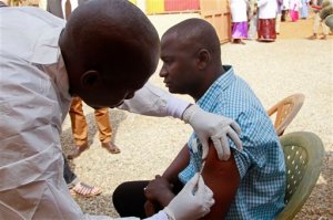 FILE - In this March 7, 2015 file photo, a health worker, left, injects a man in his arm with an Ebola vaccine in Conakry, Guinea. In the biggest study to test whether the blood of Ebola survivors helps patients, doctors found the experimental treatment didnt make a difference and some scientists say its time to shelve the approach.  With no licensed treatment for the devastating disease, doctors have sometimes used blood from survivors to treat the sick, hoping its infection-fighting antibodies might help patients defeat the virus. It seemed to help some patients in the past but there was no clear proof. Amid the worlds biggest outbreak of Ebola in West Africa in 2014, scientists decided to put the treatment to the test in Guinea.  (AP Photo/Youssouf Bah, File)