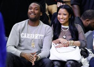 FILE - In this Jan. 16, 2016 file photo, Nicki Minaj, right, and Meek Mill, left, watch action from the sidelines during the first half of an NBA basketball game between the Portland Trail Blazers and the Philadelphia 76ers, in Philadelphia. Mill must serve three months of house arrest for parole violations that he blames on his erratic concert schedule but Philadelphia prosecutors link to his romance with Minaj. Common Pleas Judge Genece Brinkley also ordered him to spend six more years on probation.(AP Photo/Chris Szagola, File)