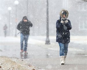 University of Illinois student Charmaine Espinosa bundles up as she walks to class through falling snow on the UI campus in Urbana, Ill., on Wednesday, Feb. 24, 2016. A powerful storm moving through parts of the Midwest on Wednesday could dump more than a foot of snow in places, leading to the pre-emptive cancellation of hundreds of flights in and out of Chicago and the cancellation of classes by some school districts. (John Dixon/The News-Gazette via AP)  MANDATORY CREDIT