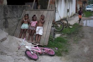 In this Jan. 29, 2016 photo, youth play on a street with stagnate floodwater in the Parque Sao Bento shantytown in Rio de Janeiro, Brazil. Brazil's first case of Zika, a virus that was first identified in Uganda in 1947 and subsequently spread to parts of Asia, was recorded in the middle of last year. Brazil is in the midst of a Zika outbreak and authorities say they have also detected a spike in cases of microcephaly in newborn children, but the link between Zika and microcephaly is as yet unproven. Researchers don't know exactly how the virus made the jump, but the two theories that hold most currency suggest it may have arrived with one or more infected tourists visiting the country for the 2014 World Cup soccer tournament or an international canoeing competition here the same year. (AP Photo/Leo Correa)