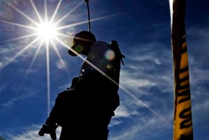Police officer Steve Blasko walks near police tape at the scene of a fatal house fire and shooting Tuesday, Feb. 23, 2016, in Phoenix. Officers dodged bullets fired by the shooter and donned breathing gear to enter the burning home to help the victims. (AP Photo/Morry Gash)