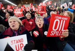 Maureen Hildreth, center, attends a public hearing on a proposed massive oil-handling facility in southwest Washington, Tuesday, Jan. 5, 2016, in Ridgefield, Wash. Tesoro Corp. and Savage Cos., operating as Vancouver Energy, want to build a rail-to-marine oil transfer terminal along the Columbia River that can handle an average 360,000 barrels of crude per day. (Natalie Behring/The Columbian via AP) MANDATORY CREDIT