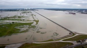 CORRECTS TO REFLECT POOL STATUS OF PHOTO - Workers with the U.S. Army Corps of engineers drain water from the Mississippi River, right, into the Bonnet Carre Spillway Sunday, Jan. 10, 2016, in Norco, La. The Mississippi River water levels are rising because of heavy December rain in the Midwest. The opening of the Bonnet Carre Spillway helps relieve pressure on New Orleans-area levees by making sure the water doesnt flow faster than 1.25 million cubic feet per second through the city.  (Scott Threlkeld/The Advocate via AP, Pool)