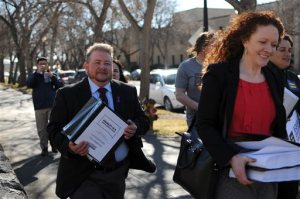 Terri Bruce, left, a transgender man who opposes a bill before South Dakota Gov. Dennis Daugaard that would limit transgender student bathroom use, walks toward the South Dakota state Capitol in Pierre, S.D., Tuesday, Feb. 23, 2016. Opponents of the bill say they delivered more than 80,000 signatures to Daugaard pushing him to veto the bill. (AP Photo/James Nord)