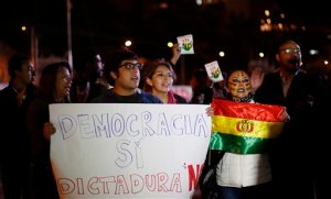 Demonstrators shout slogans against Bolivian President Evo Morales, demanding he concede, while waiting for the official results of a constitutional referendum outside a vote counting center in La Paz, Bolivia, Tuesday, Feb. 23, 2016. With 95 percent of the vote counted Tuesday, results showed 52 percent of voters rejecting Morales' bid to change the constitution so he can run for a fourth consecutive term in 2019. Morales said Monday he was not abandoning hope despite indications Bolivians had rejected the referendum by a slim margin. (AP Photo/Juan Karita)