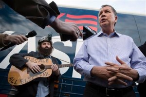 Republican presidential candidate Ohio Gov. John Kasich speaks to the media alongside musician Rod Webber during a campaign stop at the Derry-Salem Elks Lodge, Sunday, Jan. 31, 2016, in Salem, N.H. (AP Photo/John Minchillo)