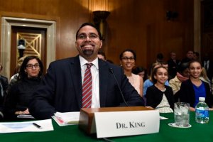 Acting Education Secretary Dr. John King, Jr., second from left, sits down to testify before the Senate Health, Education, Labor and Pensions Committee on Capitol Hill in Washington, Thursday, Feb. 25, 2016, during his confirmation hearing as the Education Secretary as his wife Melissa, third from right, and daughters Mireya, second from right, and Amina, right, watch.  (AP Photo/Susan Walsh)