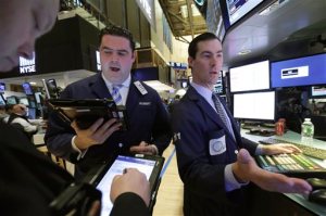 Trader Robert McQuade and specialist John McNierney, right, work on the floor of the New York Stock Exchange, Wednesday, Feb. 24, 2016. Stocks are opening lower on Wall Street, led by declines in energy companies and banks as commodity prices fall. (AP Photo/Richard Drew)