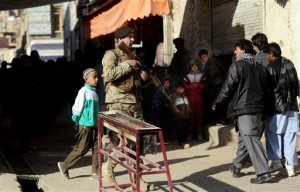 An Afghan security officer stands guard near the site of a suicide attack at the gate of a Civil Order Police compound, in Kabul, Afghanistan, Monday, Feb. 1, 2016. A suicide car bombing aimed at a police base in Afghanistan's capital has killed at least one person and wounded more than a dozen. (AP Photos/Massoud Hossaini)