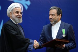 Iranian President Hassan Rouhani, left, shakes hand with Iran's deputy Foreign Minister and senior nuclear negotiator Abbas Araghchi after awarding him a medal of honor in a ceremony in Tehran, Iran, Monday, Feb. 8, 2016. Iran awarded medals of honor on Monday to its nuclear negotiators who helped clinch a landmark deal with world powers last year. (AP Photo/Ebrahim Noroozi)