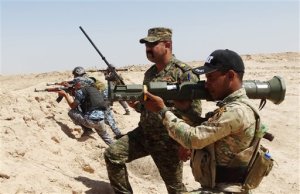 FILE - In this Thursday, July, 23, 2015 file photo, Iraqi Army soldiers with new U.S.-made weapons take combat positions at the front line in an eastern suburb of Ramadi, backed by Shiite and Sunni pro-government fighters and U.S.-led coalition airstrikes against Islamic State group positions in Anbar province, Iraq.  It will take many more months to prepare Iraqs still struggling military for a long-anticipated assault on the Islamic State groups biggest stronghold in the country, the city of Mosul, U.S. and Iraqi officials say _ and it may not even be possible to retake it this year, despite repeated vows by Prime Minister Haider al-Abadi. (AP Photo)