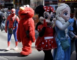 Costumed characters work for tips in Times Square in New York, Tuesday, March 29, 2016. The costumed characters, naked painted ladies and bus tour ticket sellers who have made all of Times Square their stomping grounds could be restricted to specific zones under legislation being considered by the City Council. The councils committee on transportation is holding a hearing Wednesday morning on legislation that would allow the citys Department of Transportation to create rules and regulations for pedestrian plazas like the ones in Times Square. (AP Photo/Seth Wenig)