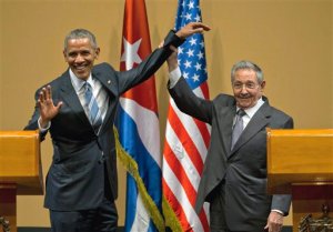 In this Monday, March 21, 2016 photo, Cuban President Raul Castro, right, lifts up the arm of President Barack Obama at the conclusion of their joint news conference at the Palace of the Revolution in Havana, Cuba. Brushing off decades of distrust, Obama and Castro shook hands, a remarkable moment for two countries working to put the bitterness of their Cold War-era enmity behind them. (AP Photo/Ramon Espinosa)