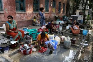 Residents of an area gather around a roadside water source to wash their clothes and fill drinking water for their houses in Kolkata, India, Tuesday, March 22, 2016. A report says India has the world's highest number of people without access to clean water. The international charity Water Aid says 75.8 million Indians or 5 percent of the country's 1.25 billion population are forced to either buy water at high rates or use supplies that are contaminated with sewage or chemicals. (AP Photo/Bikas Das)