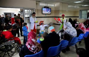 In this Thursday, March 17, 2016 photo, Palestinian clown doctors, 24-year-old Majed Kaloub, top center, and 33-year-old Alaa Miqdad, bottom center, perform for children during their visit at the Al-Rantisi childrens hospital in Gaza City. Majed and Alaa were not trained in hospital clowning, but they grew up in a place that saw three large-scale military conflicts between Israel and Gazas Hamas rulers in the past decade, let alone dozens of smaller rounds of violence. Both visit three medical centers in the Gaza Strip a week and spend two days at Al-Rantisi, a specialized hospital for children with chronic illnesses. (AP Photo/Adel Hana)