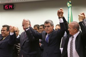 The speaker of Brazil's lower house of Congress Eduardo Cunha, from second front left, Romero Juca, vice president of Brazil's largest party, the Democratic Movement Party (PMDB), and Eliseu Padilha, a former transportation minister, celebrate their decision to abandon President Dilma Rousseff's governing coalition, at the National Congress, in Brasilia, Brazil, Tuesday, March 29, 2016. The decision diminishes the possibility that Rousseff will survive mounting pressure in Congress for her impeachment. The leader of the PMDB is Brazil's Vice President Michel Temer, who would assume the presidency if Rousseff is impeached for breaking fiscal laws. (AP Photo/Eraldo Peres)