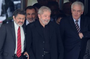 Brazils former President Luiz Inacio Lula da Silva, center, smiles as he leaves a breakfast with senators of the government's allied base, in Brasilia, Brazil, Wednesday, March 9, 2016. (AP Photo/Eraldo Peres)