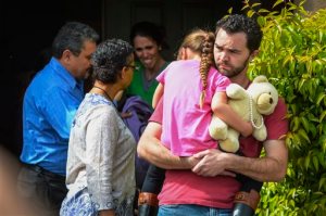Rusty Page carries Lexi while Summer Page, in the background, cries as members of family services, left, arrive to take Lexi away from her foster family in Santa Clarita, Calif., Monday, March 21, 2016. Lexi, who spent most of her life with California foster parents, was removed from her home on Monday under a court order that concluded her native American blood requires her placement with relatives in Utah. (David Crane/Los Angeles Daily News via AP) MANDATORY CREDIT