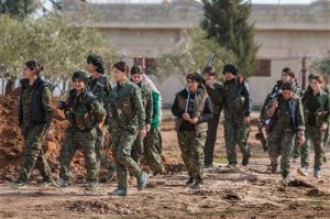 FILE - In this file photo released on May 16, 2015, provided by the Kurdish fighters of the People's Protection Units (YPG), which has been authenticated based on its contents and other AP reporting, Kurdish female fighters of the YPG, carry their weapons as they walk in the frontline of Kery Sabee village, northeast Syria. A spokesman for a powerful Syrian Kurdish political party said on Wednesday, March 16, 2016 that his faction is planning to declare a federal region in northern Syria, a model it hopes can be applied to the entire country. (The Kurdish fighters of the People's Protection Units via AP, File)