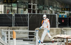 A forensics officer works in front of the damaged Zaventem Airport terminal in Brussels on Wednesday, March 23, 2016. Belgian authorities were searching Wednesday for a top suspect in the country's deadliest attacks in decades, as the European Union's capital awoke under guard and with limited public transport after scores were killed and injured in bombings on the Brussels airport and a subway station. (AP Photo/Geert Vanden Wijngaert, Pool)