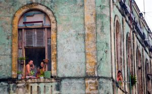 Local Cubans watch from their homes as the motorcade of U.S. President Barack Obama arrives in a section of Old Havana, Sunday, March 20, 2016 in Havana, Cuba. Obama became the first U.S. president to visit the island in nearly 90 years. (AP Photo/Pablo Martinez Monsivais)