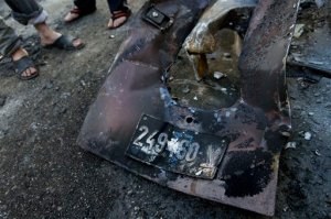 Palestinians inspect abandoned parts with the registration plate of an Israeli army vehicle that was burned during an Israeli army raid in the West Bank refugee camp of Qalandia, at the outskirts of Ramallah, Tuesday, March 1, 2016. Israeli troops raided a Palestinian refugee camp north of Jerusalem early Tuesday to rescue a pair of soldiers who had lost their way and came under attack in the area, the military said. Palestinian health officials said 22 year-old Palestinian Eyad Sajadiyeh was killed and four others were wounded in the ensuing clashes. (AP Photo/Nasser Nasser)