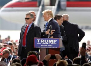 Security personnel surround Republican presidential candidate Donald Trump after a man tried to rush the stage during a rally in Vandalia, Ohio, outside of Dayton, on Saturday, March 12, 2016. The man was stopped and Trump continued with his speech. (Lisa Powell/The Dayton Daily News via AP)  LOCAL PRINT OUT; LOCAL TELEVISION OUT; WKEF-TV OUT; WRGT-TV OUT; WDTN-TV OUT; MANDATORY CREDIT