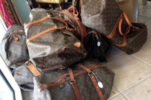 In this Feb. 25, 2016 photo, a variety of Louis Vuitton bags are seen at the Paradise Lost consignment store in Palm Beach, Fla. The island's  busy society calendar means twice-daily costume changes in a land of labels that include Chanel, Hermes, Valentino, Gucci and Prada. Many make their way to a handful of exclusive consignment boutiques and a few even trickle down to some bargain thrift shops. (AP Photo/Kelli Kennedy)