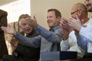 Gary Fish, founder of Deschutes Brewery holds his hands out to an applauding crowd with Gov. Terry McAuliffe, left and Deschutes Brewery representatives, right during the announcement for plans to build a production brewery Tuesday, March 22, 2016 in Roanoke, Va. Virginia will become home to Deschutes Brewery's East Coast operations after beating out North and South Carolina for the coveted facility that's expected to create more than 100 new jobs, Gov. Terry McAuliffe said Tuesday. (Heather Rousseau/The Roanoke Times via AP) LOCAL TELEVISION OUT; SALEM TIMES REGISTER OUT; FINCASTLE HERALD OUT;  CHRISTIANBURG NEWS MESSENGER OUT; RADFORD NEWS JOURNAL OUT; ROANOKE STAR SENTINEL OUT; MANDATORY CREDIT