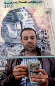 A man counts U.S dollars at an exchange office in Cairo, Egypt, Monday, March 14, 2016. Egypts central bank said it will take a more flexible approach to the exchange rate after it devalued the pound to 8.85 per U.S. dollar from a previous 7.73 on Monday, which was aimed at alleviating a foreign currency shortage that has fueled a black market and crippled businesses. (AP Photo/Amr Nabil)