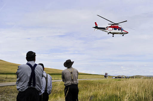 In this July 15, 2015 photo, an emergency helicopter flies over the scene of a fatal collision on Highway 287, north of Wolf Creek, Mont. Air ambulances are life-savers for many people who live in rural states such as Montana, but as the industry has grown, so too have complaints about soaring bills and the lack of regulations over the sudden influx of private companies that provide helicopter and fixed-wing emergency services. (Thom Bridge/Independent Record via AP) MANDATORY CREDIT