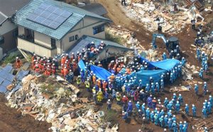 Rescuers, usuing blue plastic sheet, search for missing persons at the site of a landslide in Minamiaso, Kumamoto prefecture, Japan Tuesday, April 19, 2016. Minamiaso, a town of 12,000 on the southern island of Kyushu, was partly cut off by landslides and road and bridge damage after earthquakes. (Yohei Fukai/Kyodo News via AP) JAPAN OUT, MANDATORY CREDIT