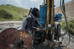 A worker adjusts a pipe that is used for pumping concrete into the ground at the Mosul Dam in northern Iraq on Thursday, April 14, 2016. A team of Italian specialists arrived Thursday at the site of the Mosul Dam as part of an emergency campaign to repair Iraq's largest dam before it collapses.(AP Photo/Alice Martins)