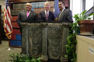 Homeland Security Investigations New York Special Agent in Charge Angel Melendez, left, Manhattan District Attorney Cyrus Vance Jr.,, center, and Pakistan's U.S. Deputy Chief of Mission Rizwan Saeed Sheikh, pose an ancient Buddhist sculpture during a news conference in Vance's offices, in New York, Wednesday, April 27, 2016. Prosecutors returned the sculpture to the government of Pakistan after a Japanese antiquities dealer pleaded guilty to smuggling it into the U.S. The 70-year-old art dealer said he was motivated partly by a desire to protect Buddhist art from being neglected or destroyed in Pakistan. (AP Photo/Richard Drew)