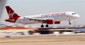 FILE - In this Dec. 1, 2010, file photo, Virgin America's inaugural flight between Los Angeles and Dallas Fort Worth International Airport comes in for a landing in Grapevine, Texas. Alaska Air Group Inc. is buying Virgin America in a deal worth more than $2 billion, creating a powerhouse airline with an expanded West Coast presence. Alaska Air said Monday, April 4, 2016, that the deal will expand its route network. (AP Photo/LM Otero, File)