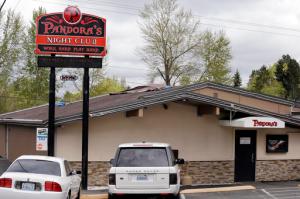 In this April 5, 2016, file photo, cars are parked outside Pandora's Adult Cabaret in Seattle. While advocates have worked hard to move the minimum wage toward $15 an hour from Seattle to from New York, experts say there may be a more daunting challenge ahead: getting businesses to obey those new laws. In 2015, Pandoras Adult Cabaret was one of the first businesses in Seattle forced to pay thousands of dollars in back wages to employees who were not paid the current wage. (AP Photo/Elaine Thompson, File)